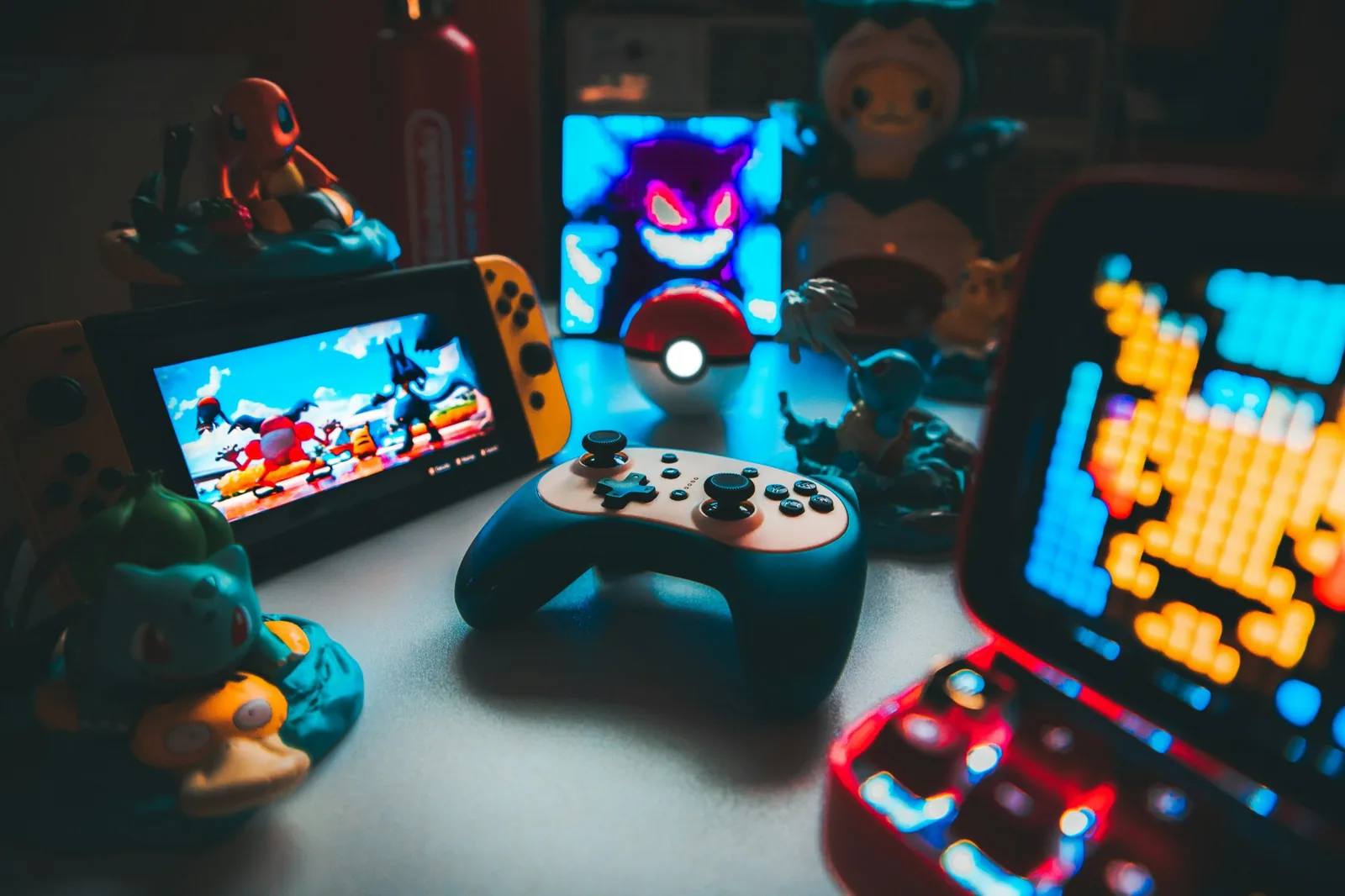 Handheld consoles, a game controller and character figures on a desk