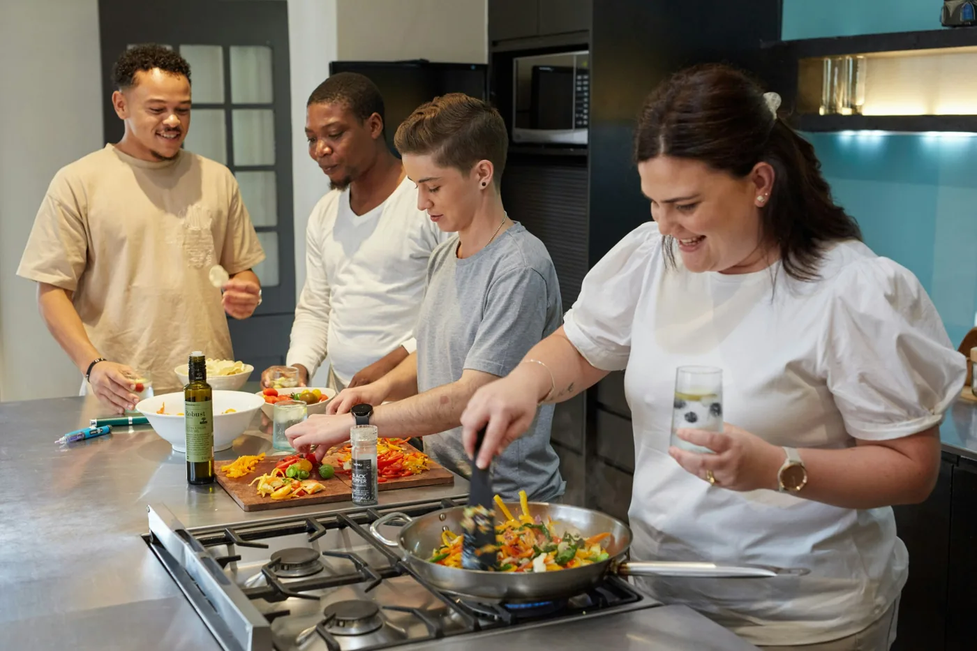 Four people cooking together at a kitchen island