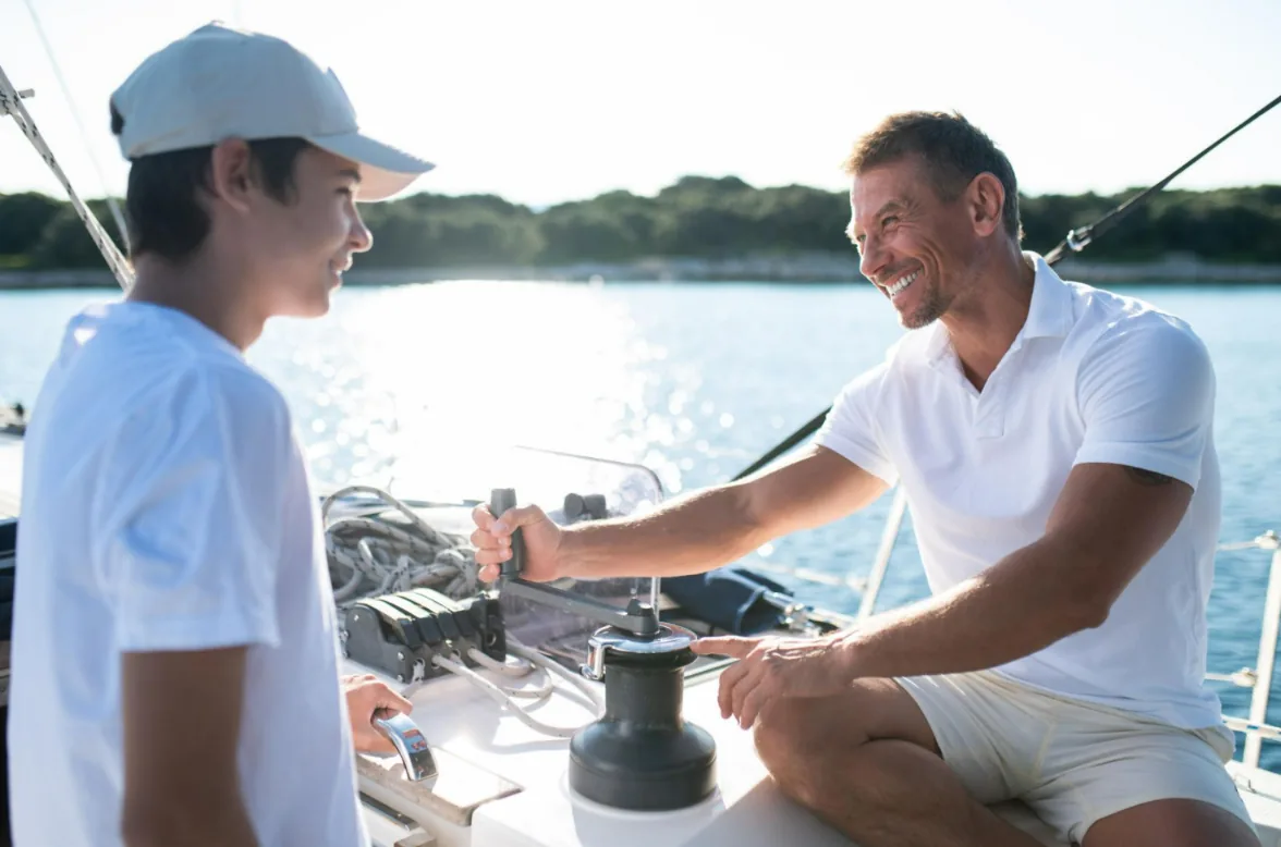 Father and son smiling together during a sailing day out