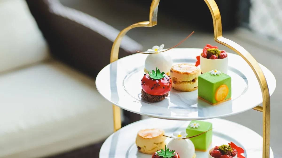 Cakes, a scone and pastries on a tiered afternoon-tea stand