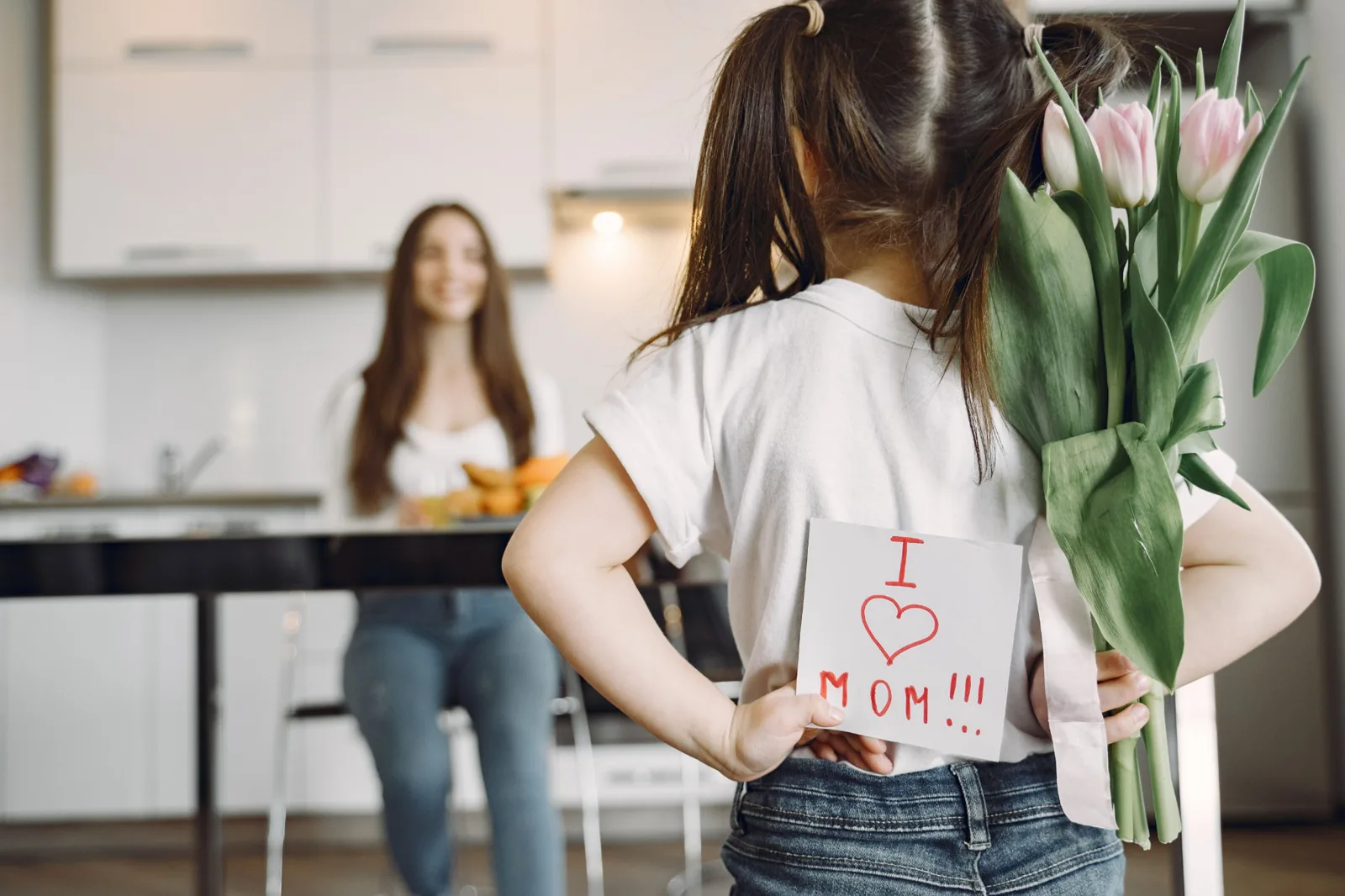 Daughter holding flowers behind her back as a surprise for Mum