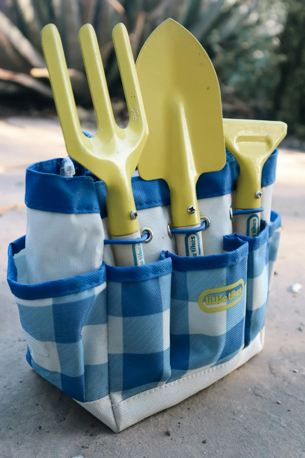 Small gardening tools in a blue fabric tool bag
