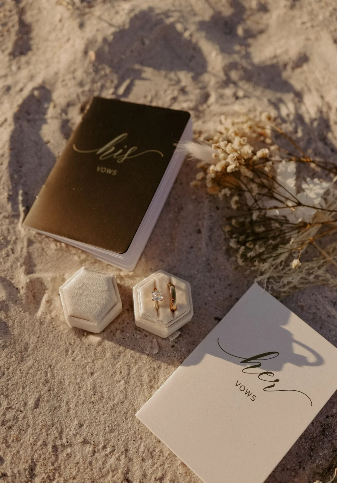 An open wedding vows booklet beside two wedding rings