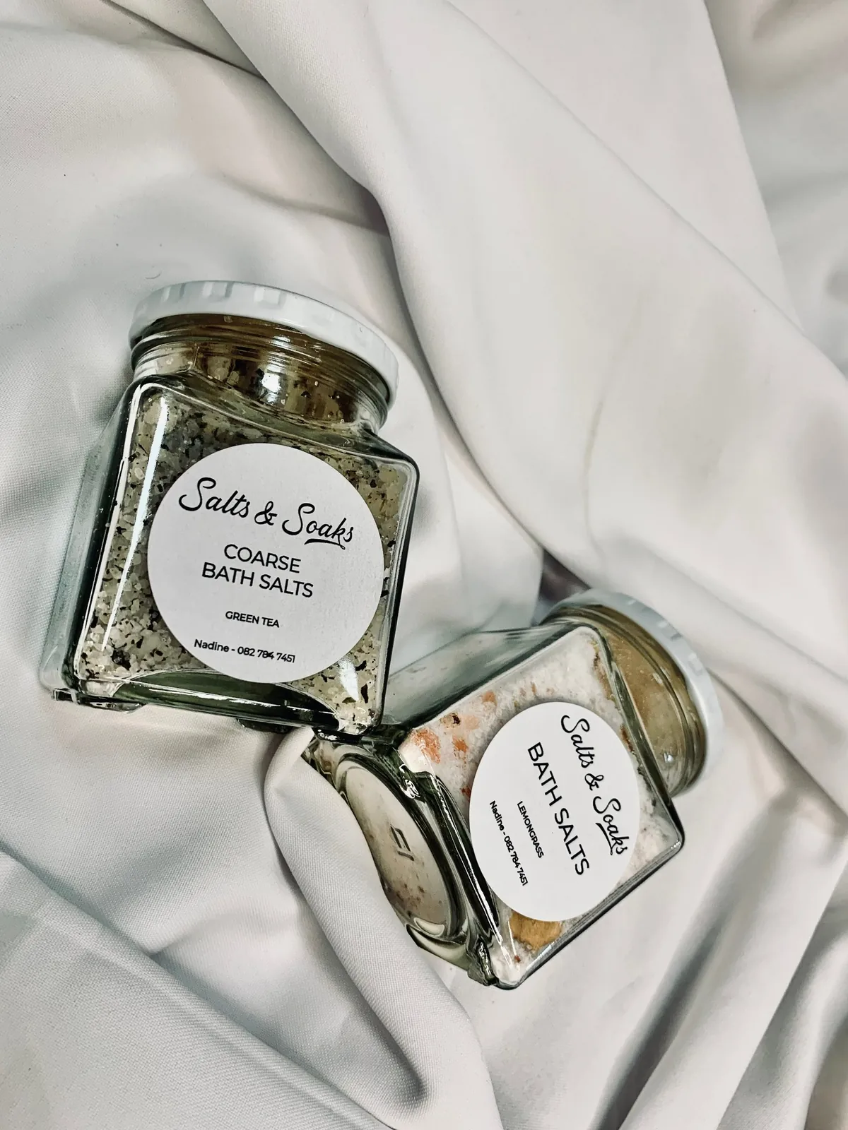 Glass jars of bath salts arranged with flowers