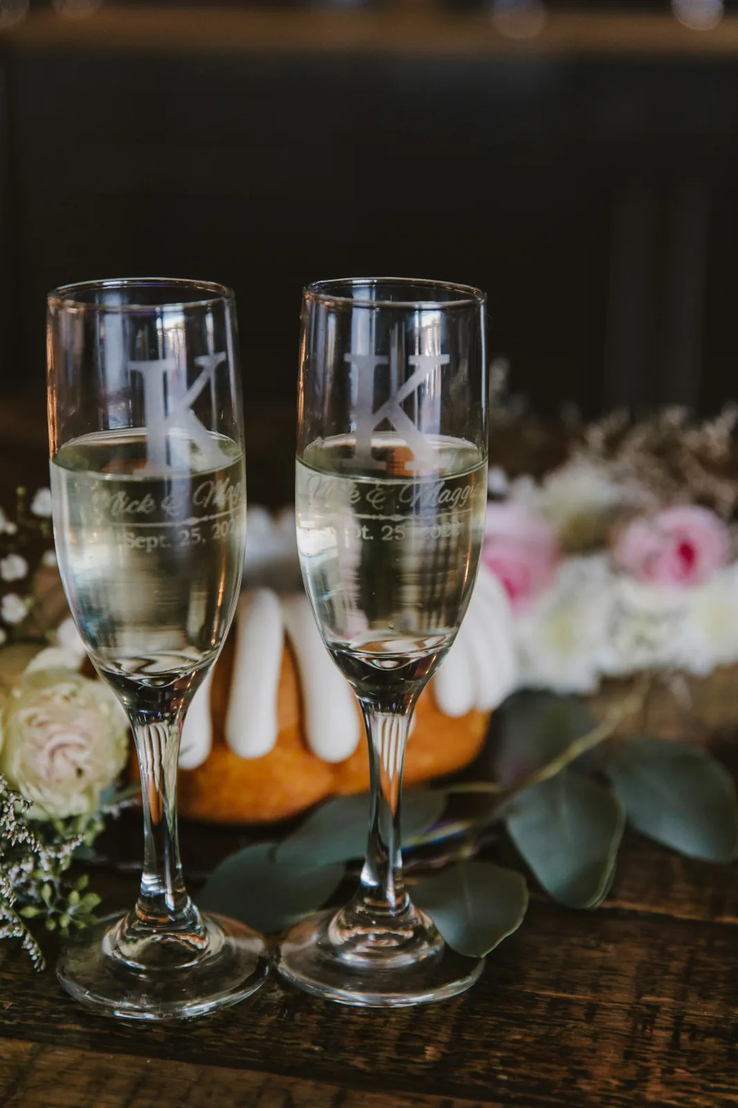 Two engraved champagne flutes. The photograph does not confirm that the glass is crystal.