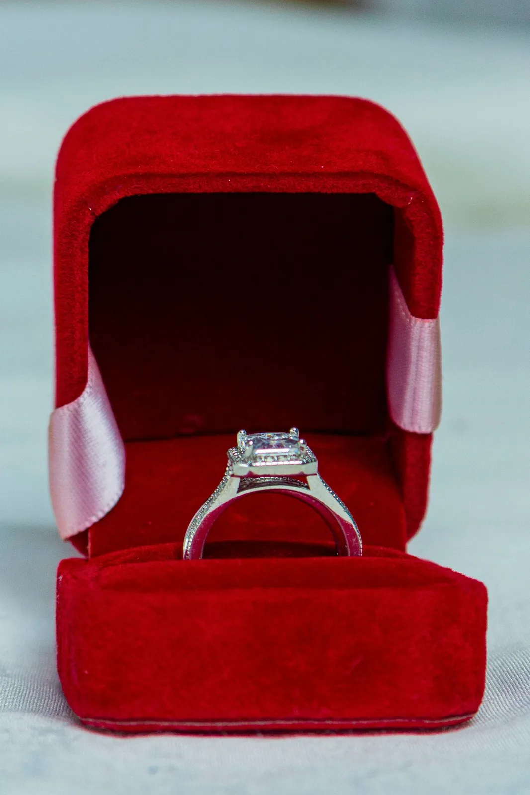 A ring in an open red velvet box. The photograph does not confirm that the stone is a diamond.